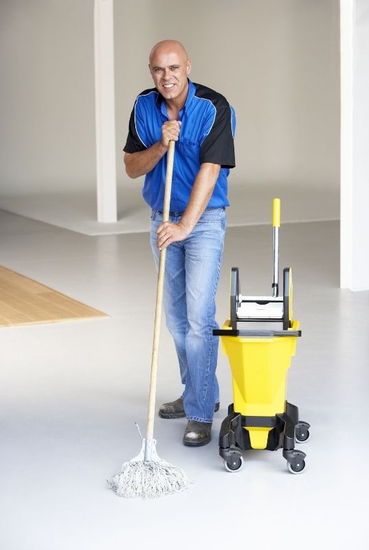 Cleaner mopping floor in commercial building