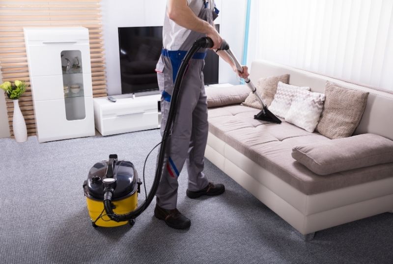 Cleaner vacuuming a couch for a end of lease Central Coast cleaning services