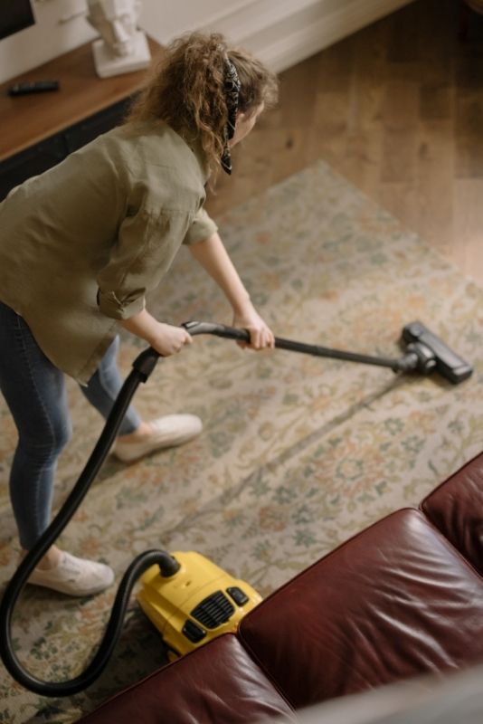 Maid from Cleaning Lake Macquarie vacuuming a rug in a living room