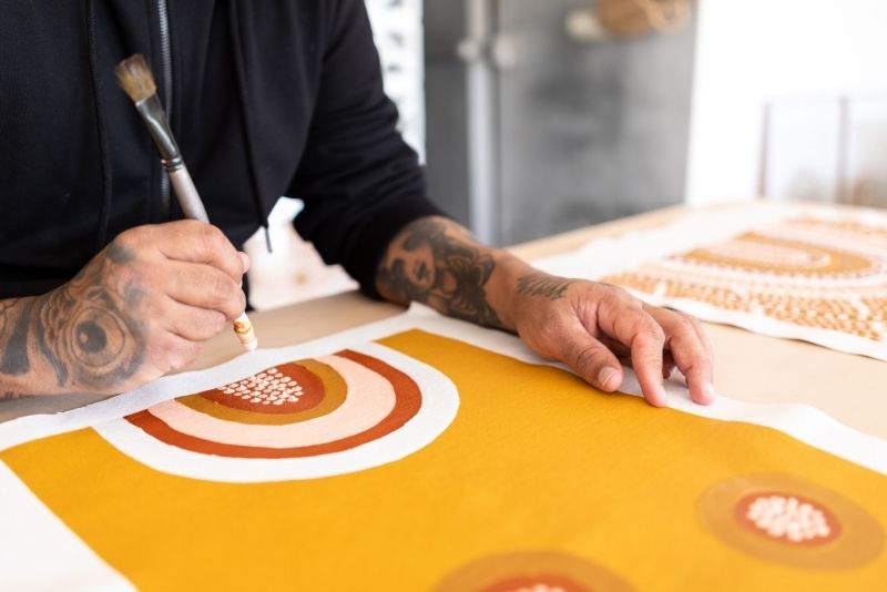 Australian aboriginal artist painting on a canva