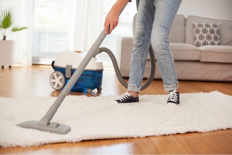 Staff from Cleaning Lake Macquarie company vacuuming a rug for a one-off services